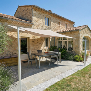 Mât télescopique aluminium Camofil soutenant un filet de camouflage sur une terrasse de villa.